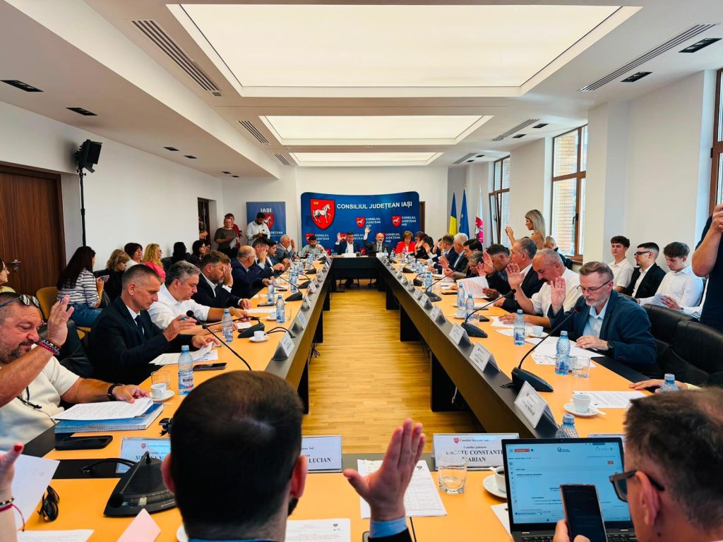 Consilieri județeni votând prin ridicare de mână într-o ședință a Consiliului Județean Iași