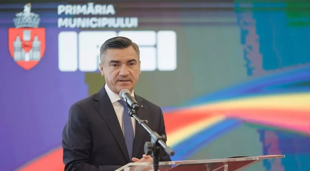 Mihai Chirica la pupitru, în fața siglei Primăriei Municipiului Iași