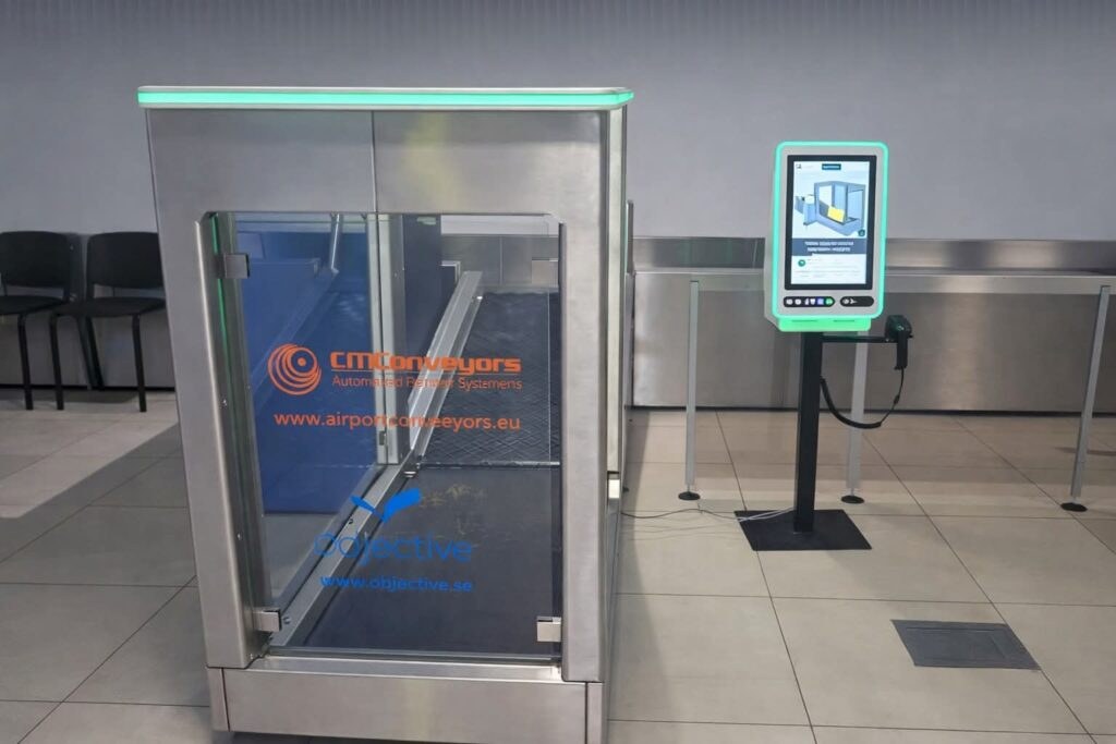 Zona de control al bagajelor din Aeroportul Iași, cu aparatul de scanare și pasageri la rând