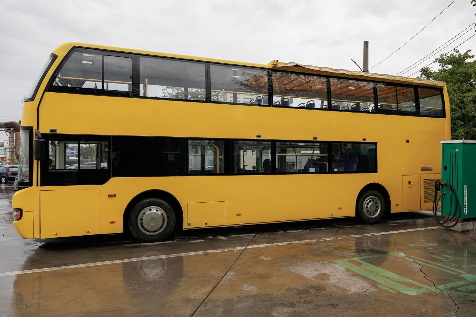 Autobuzul turistic al CTP Iasi vazut lateral, langa o statie de incarcare