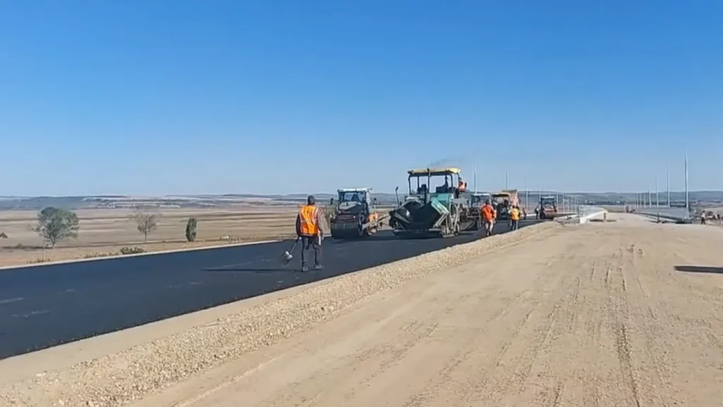 Utilaje care asfaltează pe un lot al Autostrăzii A7