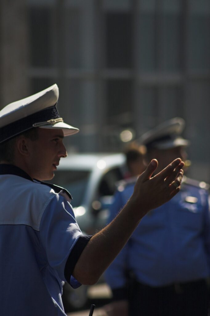 Polițist rutier dirijând circulația la Arad, cu un coleg în fundal; controlul în trafic pentru permisul uitat acasă