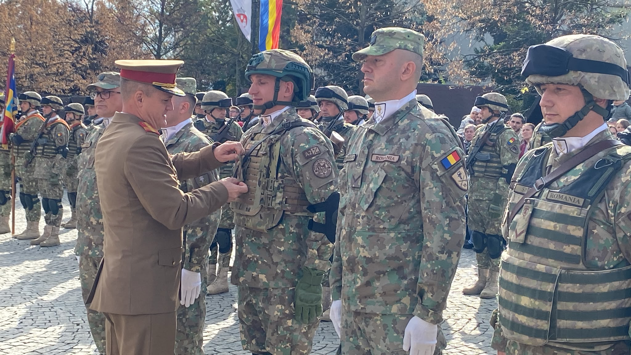 Ofițer superior înmânând o distincție unui militar aliniat în formație, la ceremonia de Ziua Armatei de la Iași